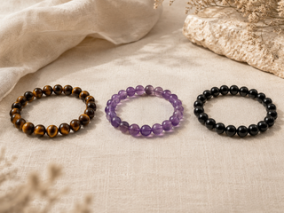 un bracelet oeil de tigre, un bracelet améthyste et un bracelet tourmaline noire cote a cote