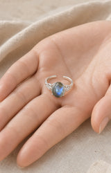 Bague réglable en labradorite présentée dans une main pour montrer son échelle