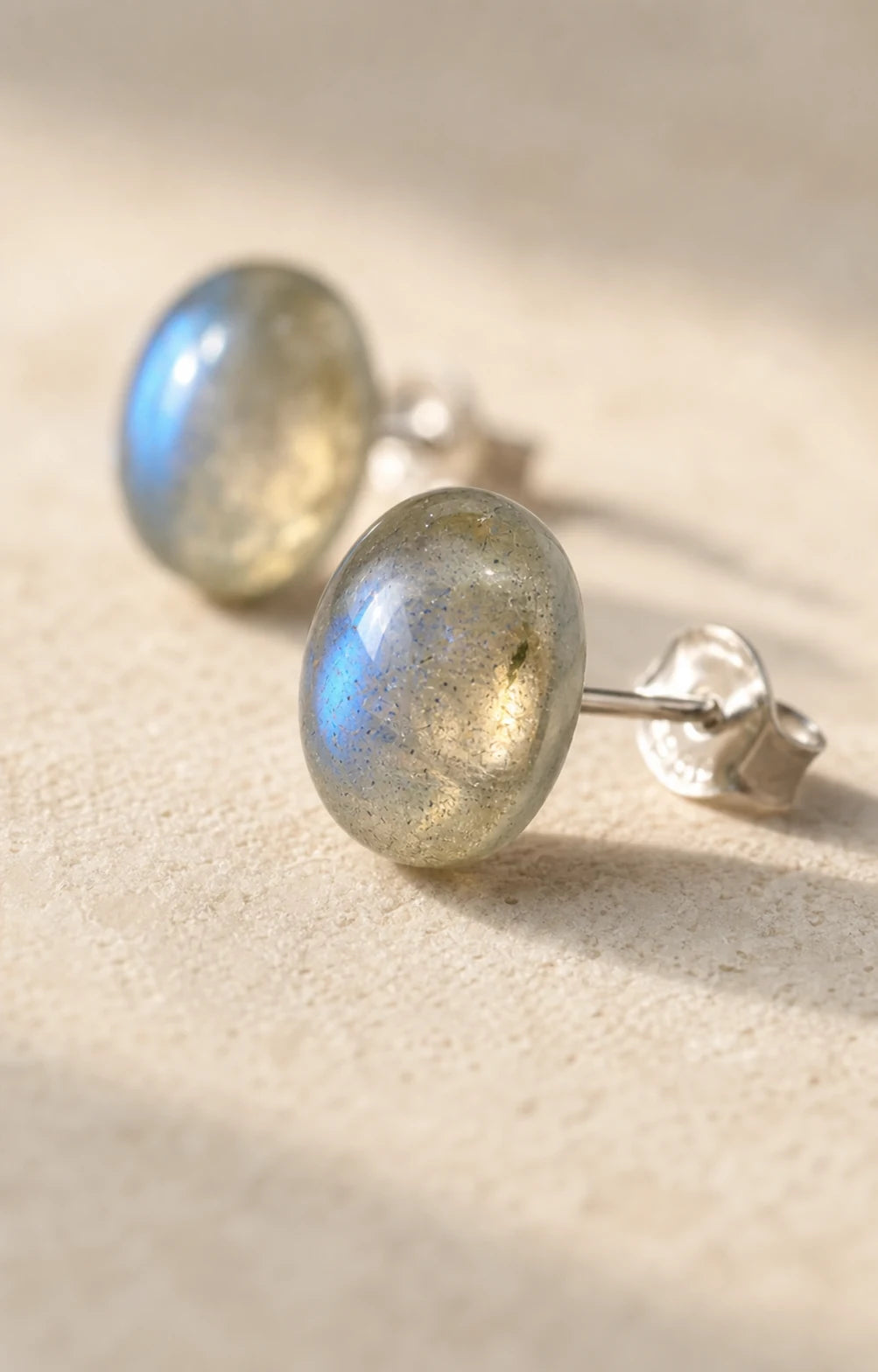 Gros plan sur la labradorite aux reflets bleu-gris et la monture en argent des clous