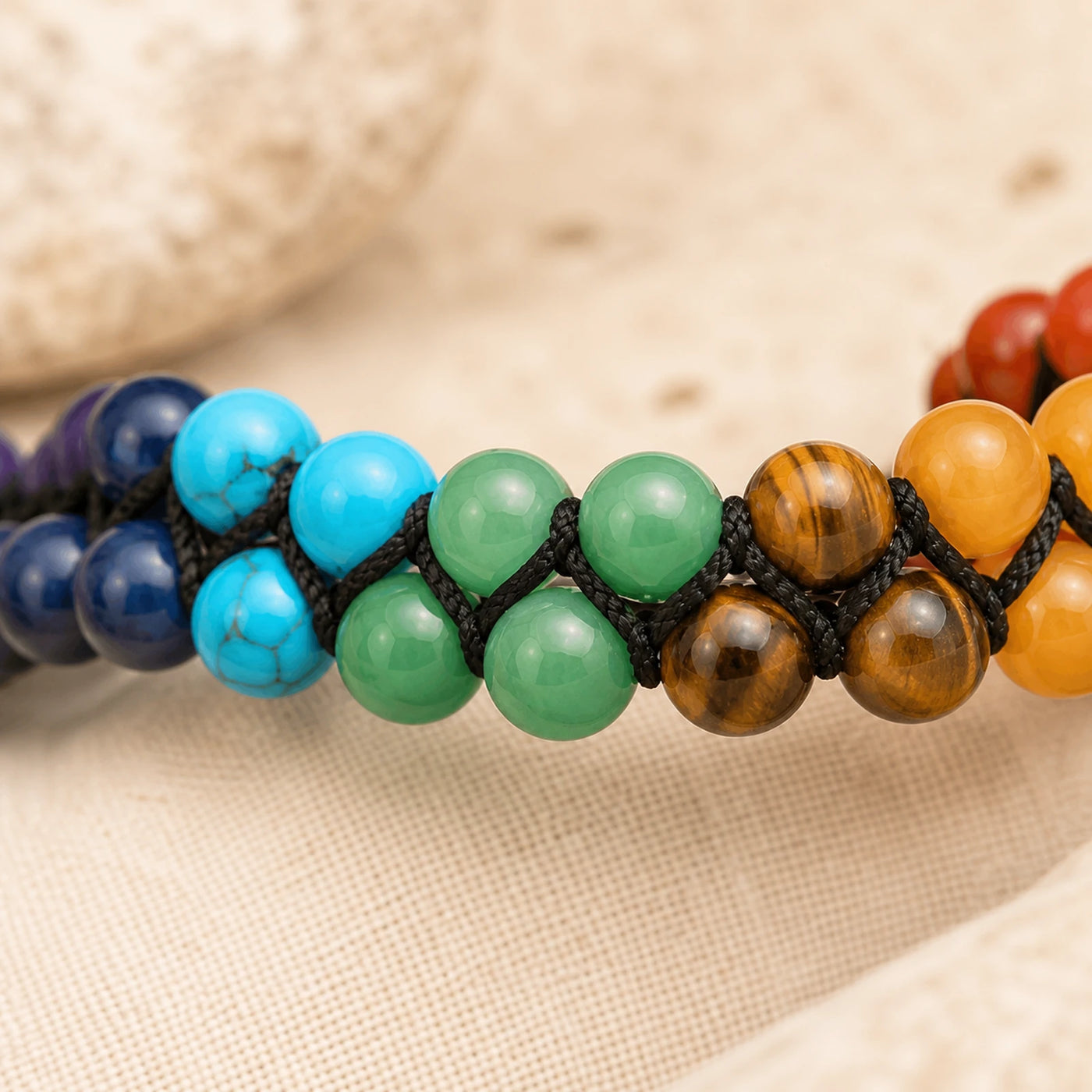 Détail des pierres naturelles colorées d’un bracelet 7 Chakras tressé.