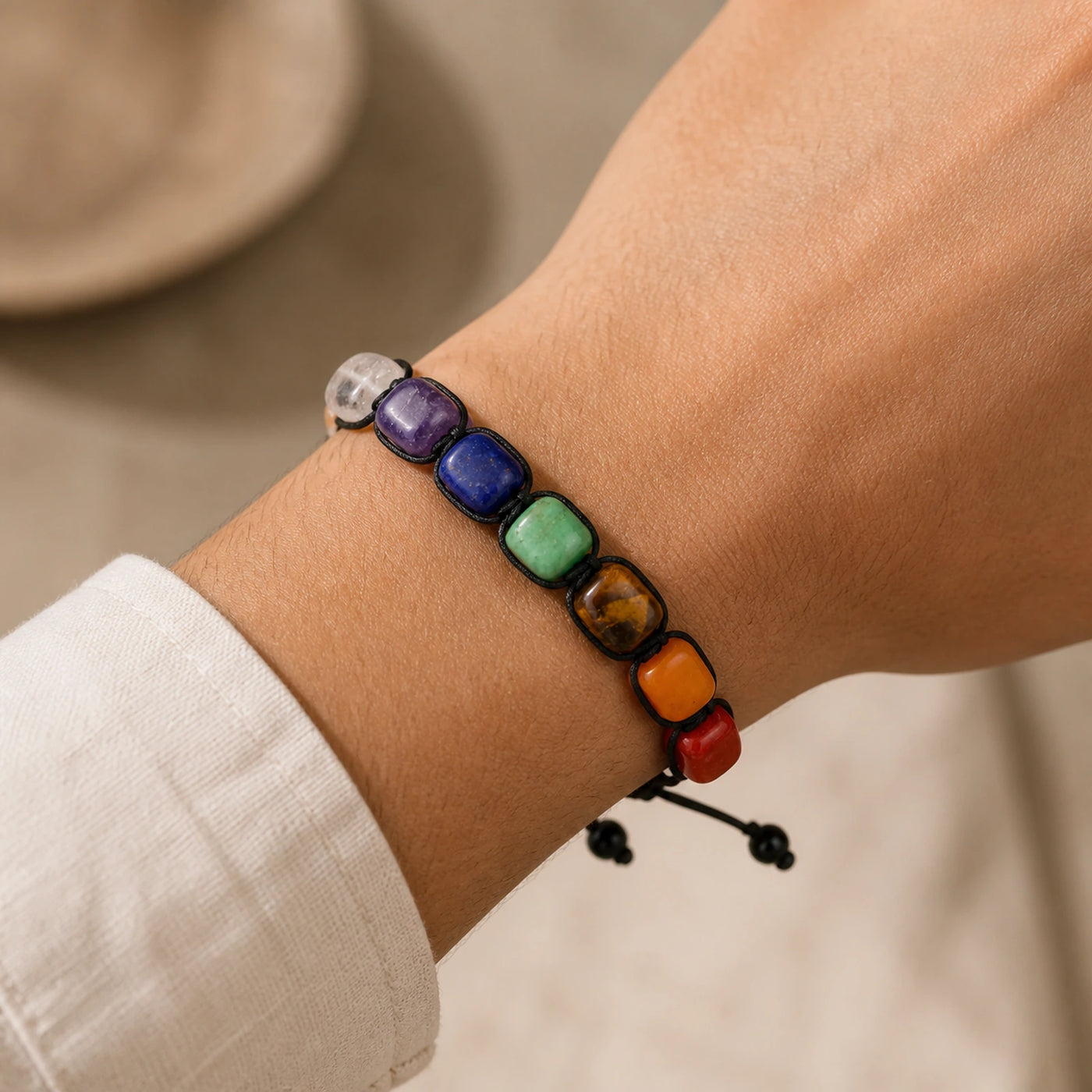 Bracelet 7 Chakras à pierres carrées porté au poignet.