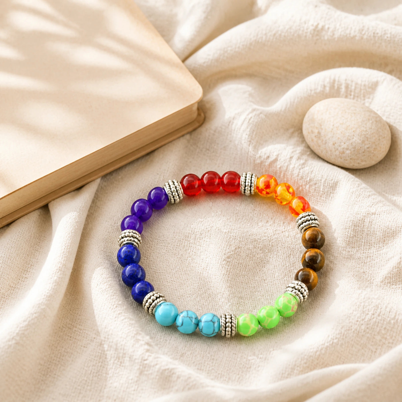 Bracelet 7 Chakras en pierres naturelles présenté sur du lin clair.