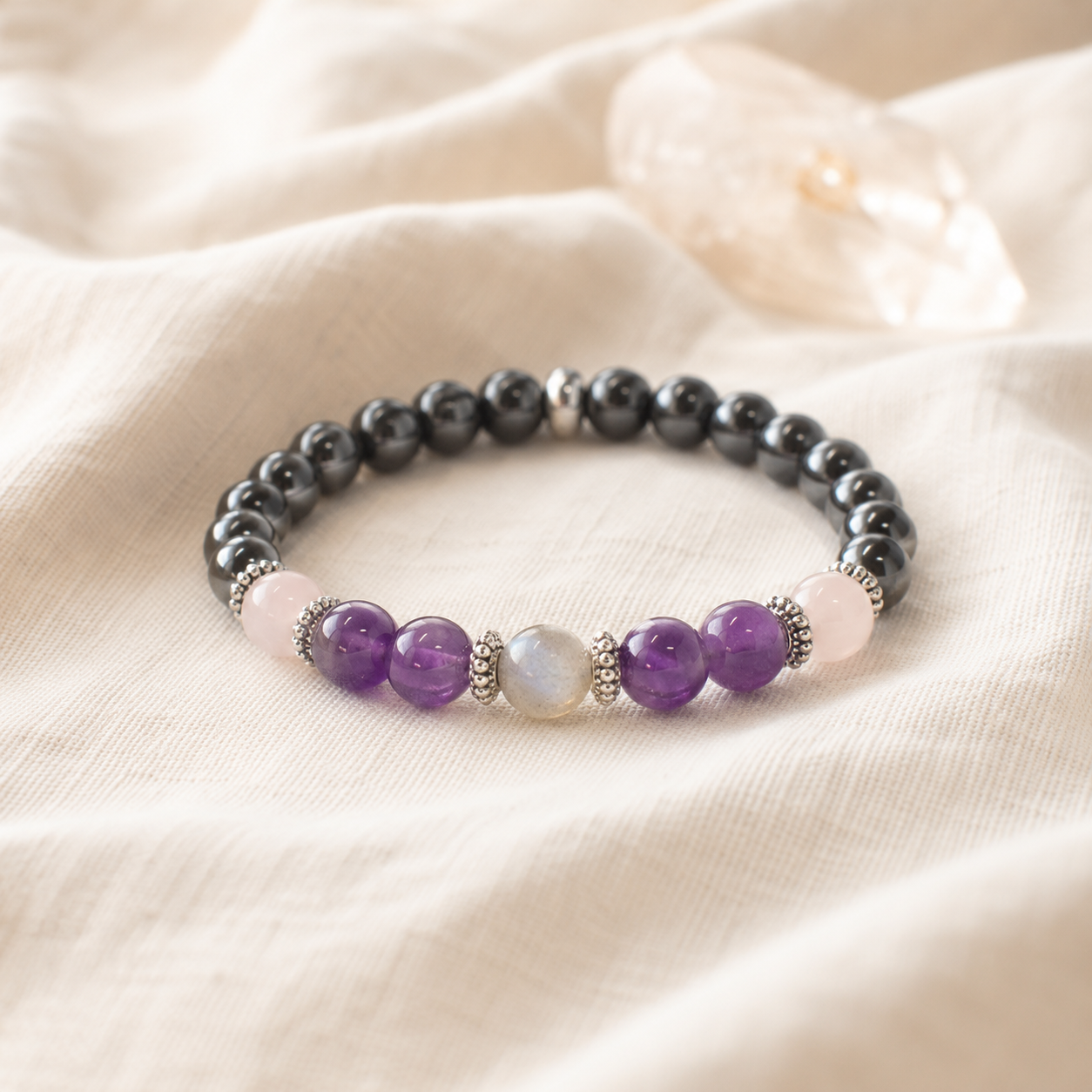 Bracelet en améthyste et hématite posé sur un tissu en lin clair