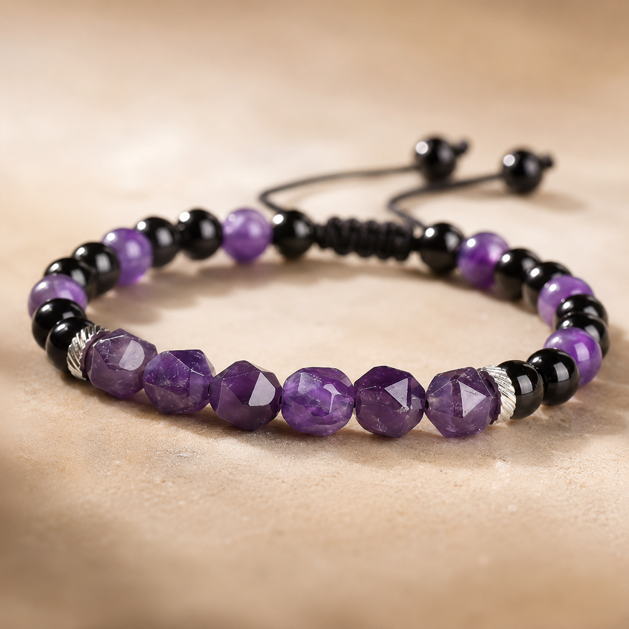 Gros plan sur les perles en améthyste facettée et onyx noir d'un bracelet réglable