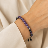 Bracelet réglable en améthyste et onyx noir porté au poignet