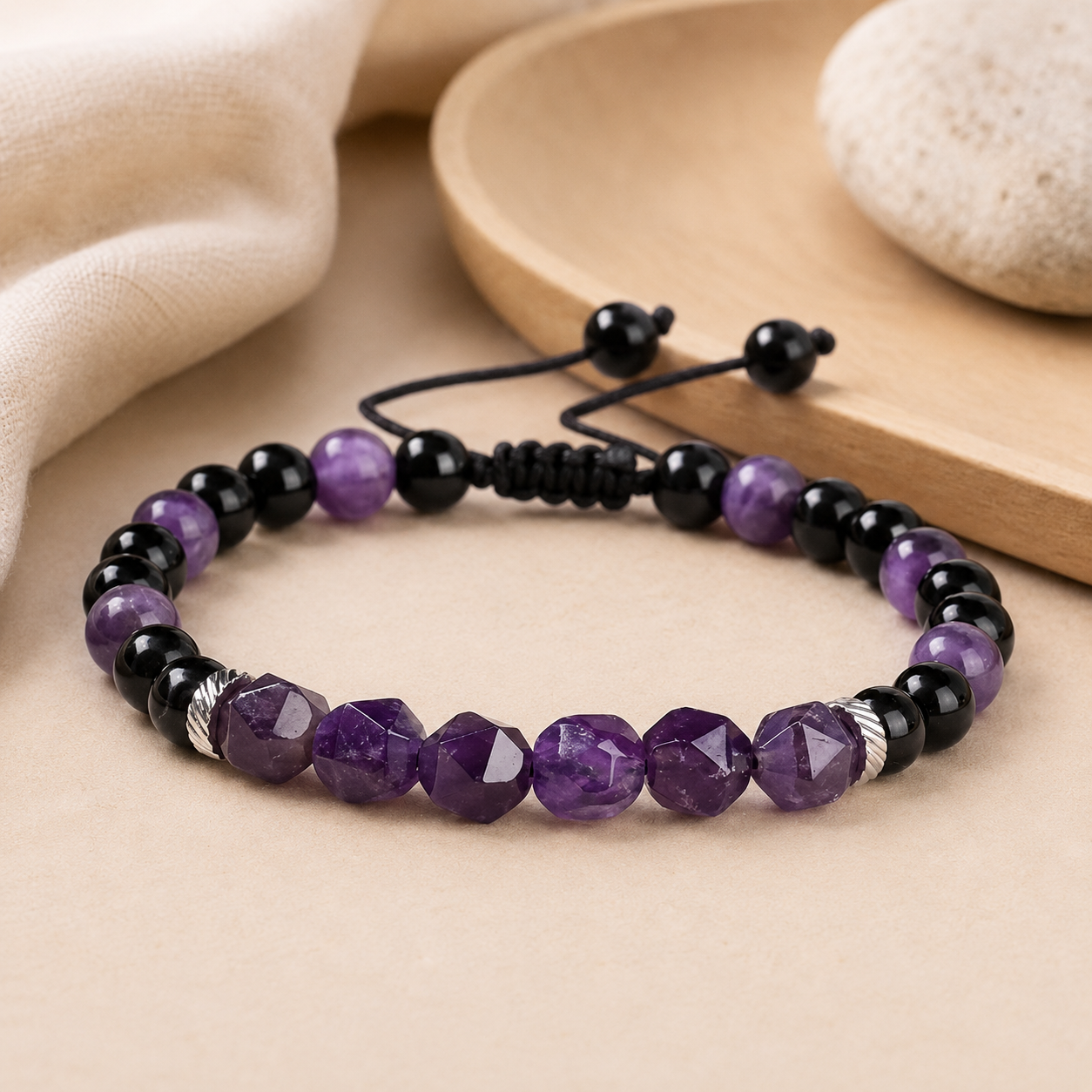 Bracelet en améthyste et onyx noir présenté dans un univers de méditation minimaliste