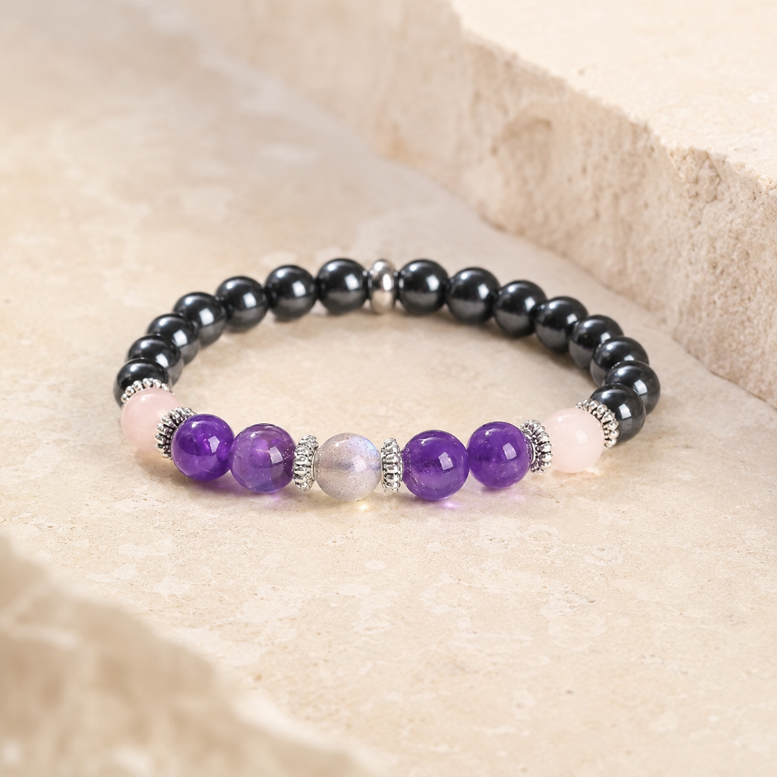 Bracelet en améthyste, quartz rose, hématite et labradorite sur pierre beige