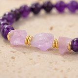 Gros plan sur les pierres brutes et les perles violettes du bracelet Elara