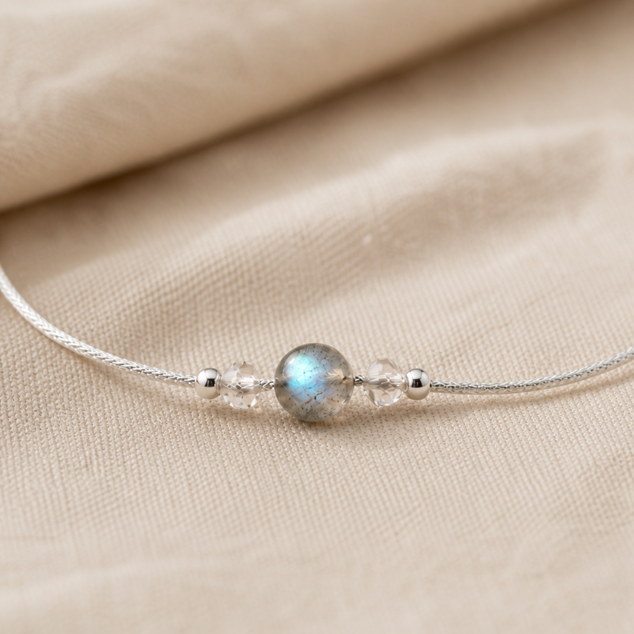 Détail de la pierre de lune ronde et des perles du bracelet en argent 925.