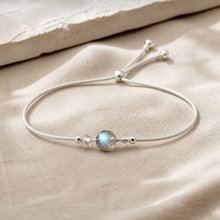 Bracelet minimaliste en argent 925 avec pierre de lune ronde sur lin clair.