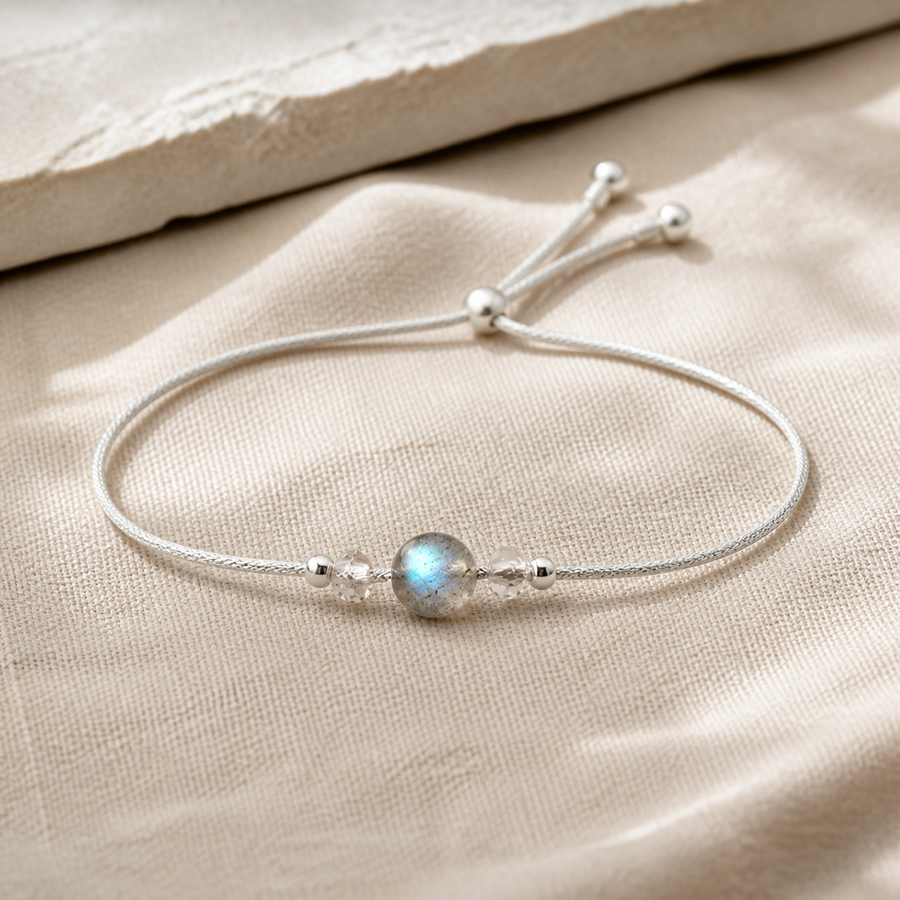 Bracelet minimaliste en argent 925 avec pierre de lune ronde sur lin clair.