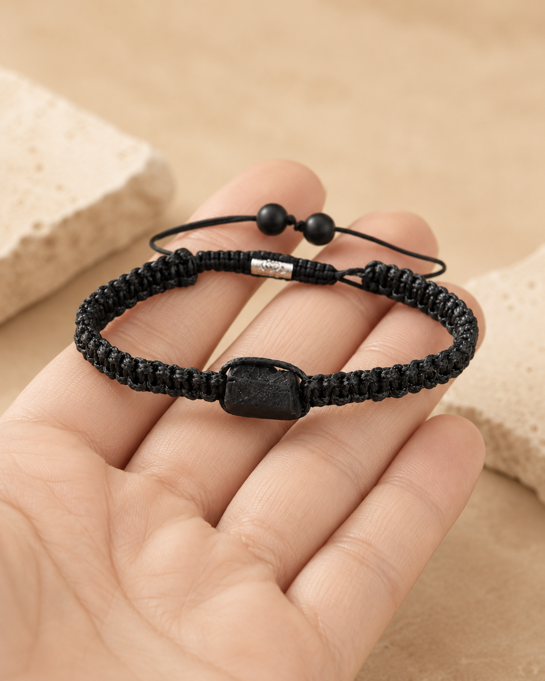 Bracelet minimaliste en tourmaline noire brute présenté dans une main pour montrer son échelle.