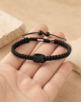Bracelet minimaliste en tourmaline noire brute présenté dans une main pour montrer son échelle.