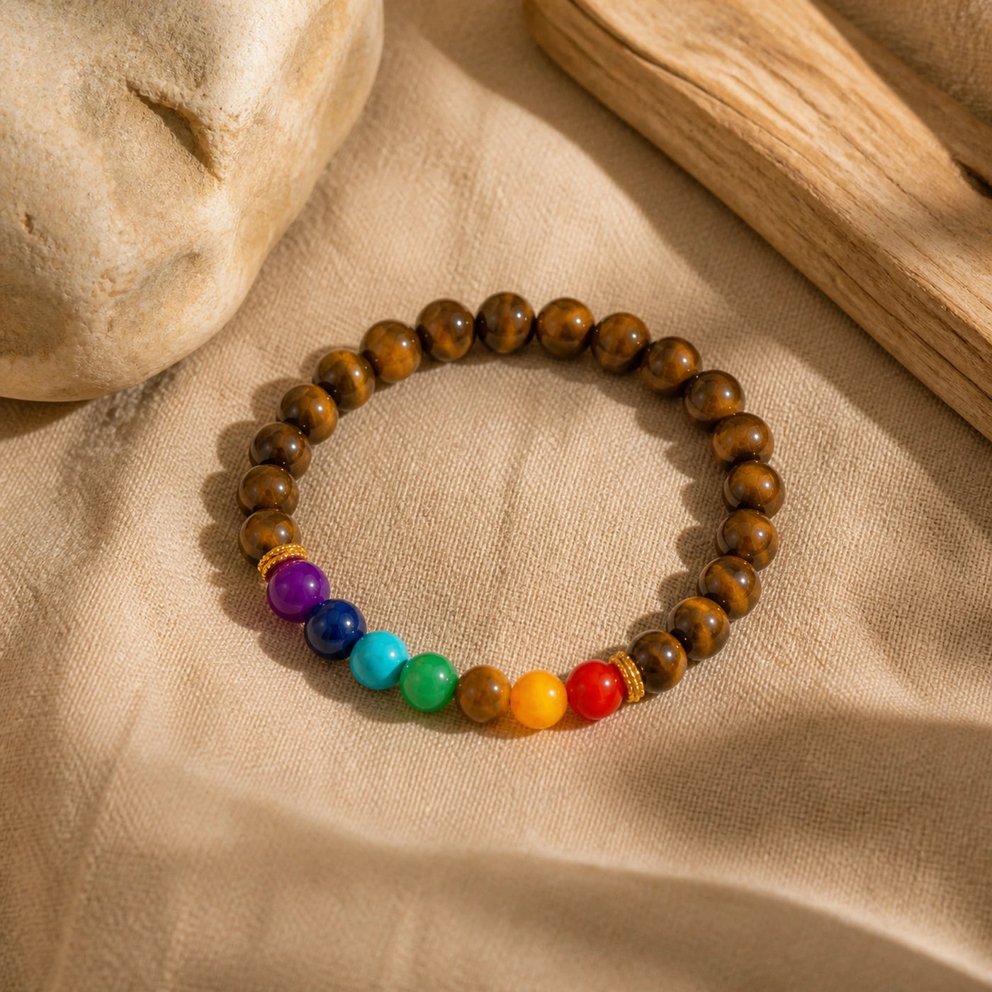 Bracelet Œil de Tigre et pierres 7 Chakras présenté sur du lin clair.