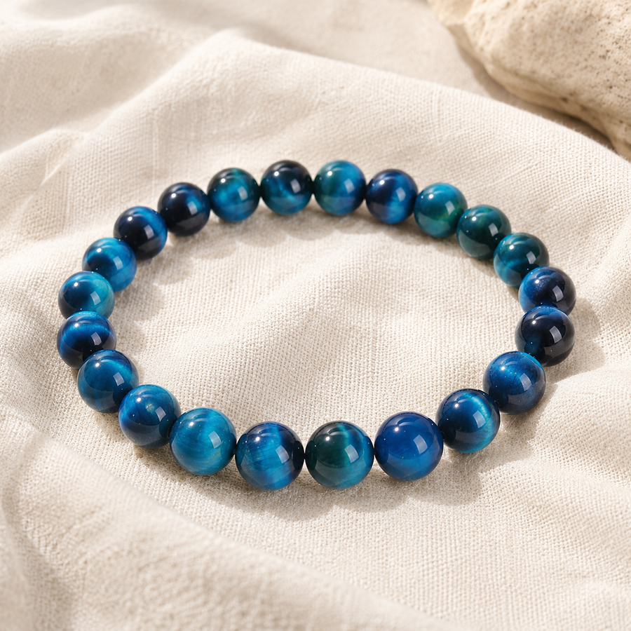 Bracelet œil de tigre bleu posé sur du lin écru