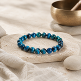 Bracelet œil de tigre bleu dans une mise en scène rituelle sobre