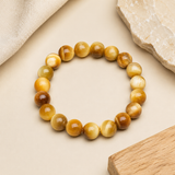 Bracelet en oeil de tigre jaune presente sur fond beige