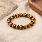 Bracelet œil de tigre posé sur du lin clair avec pierre naturelle