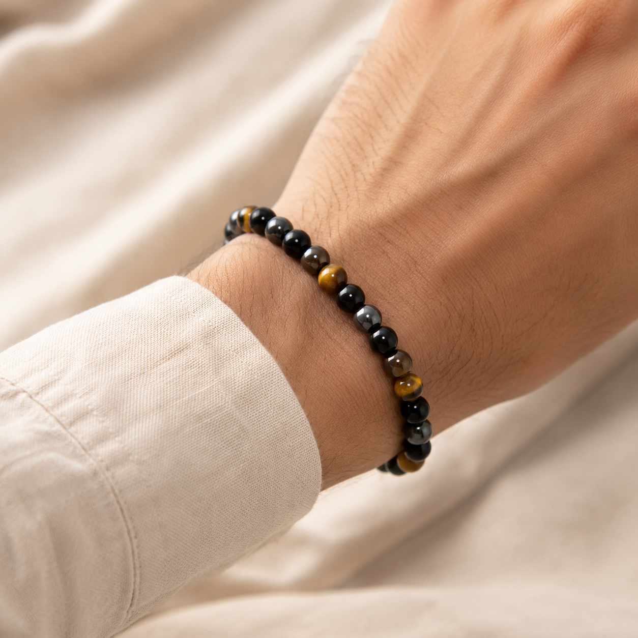 Bracelet œil de tigre, obsidienne et hématite porté au poignet