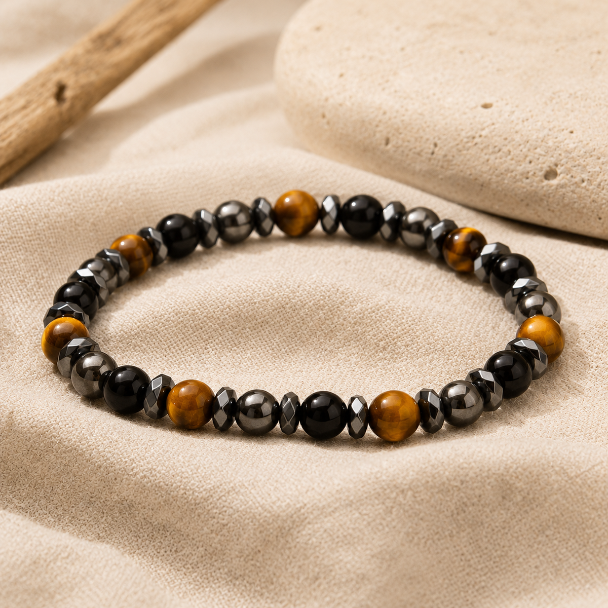 Bracelet œil de tigre et onyx noir posé sur du lin clair
