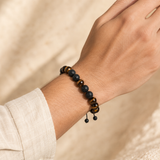 Bracelet œil de tigre et pierre de lave porté au poignet