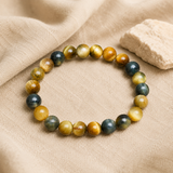 Bracelet en oeil de tigre bleu et dore sur lin clair dans une ambiance naturelle
