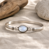 Bracelet en pierre de lune et argent 925 posé sur du lin clair.