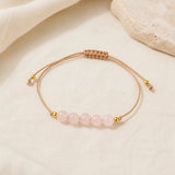 Bracelet minimaliste en quartz rose avec cordon ajustable.