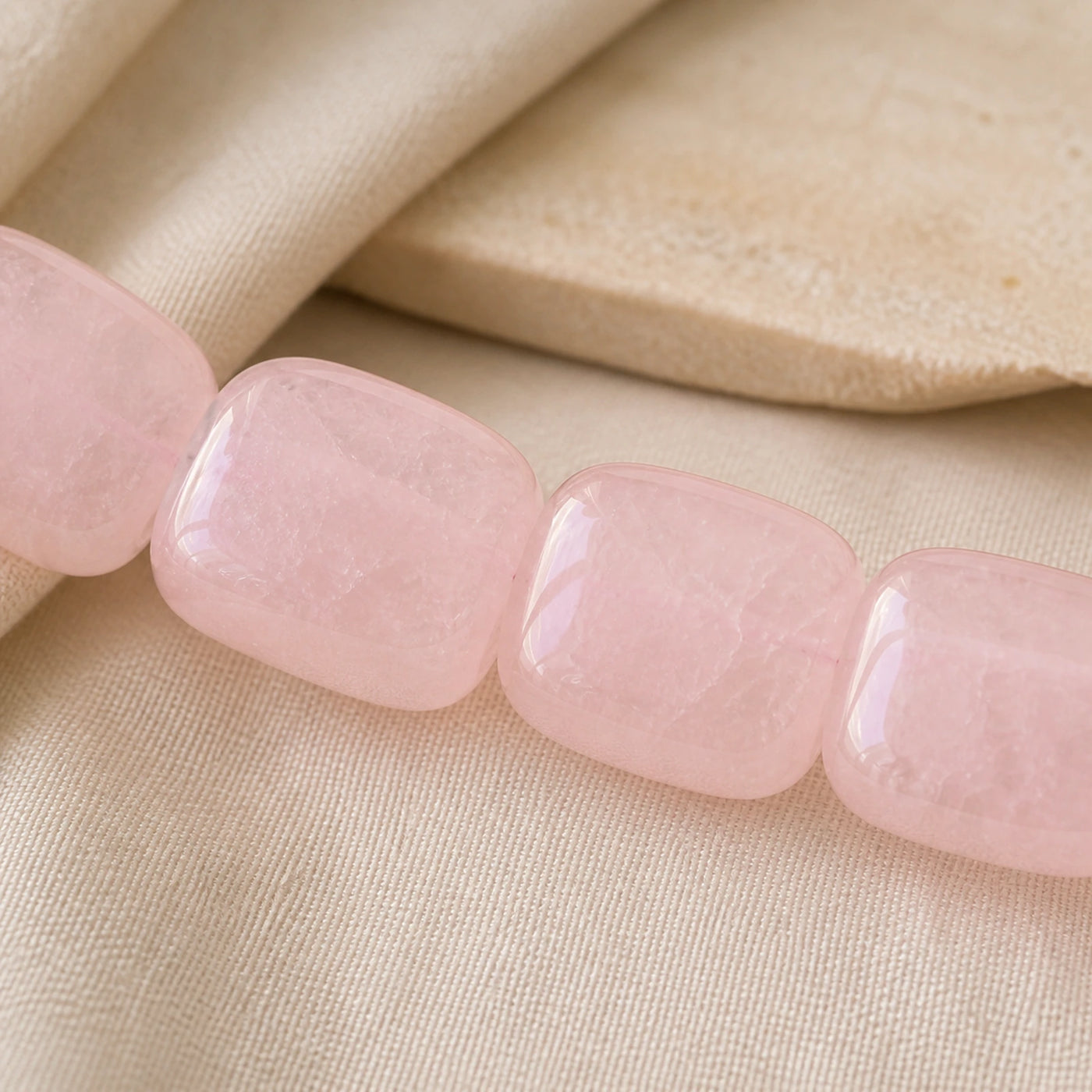 Détail des nuances naturelles de larges perles en quartz rose poli.