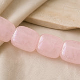 Détail des nuances naturelles de larges perles en quartz rose poli.