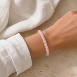 Bracelet en quartz rose à perles de 8 mm porté au poignet.