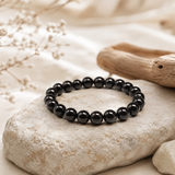 Bracelet Tourmaline Noire en Perles Naturelles présenté sur pierre beige texturée