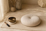 Coin méditation avec coussin, tapis beige, bol tibétain, lin clair.