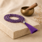 Mala en améthyste avec pompon violet dans une ambiance de méditation sobre