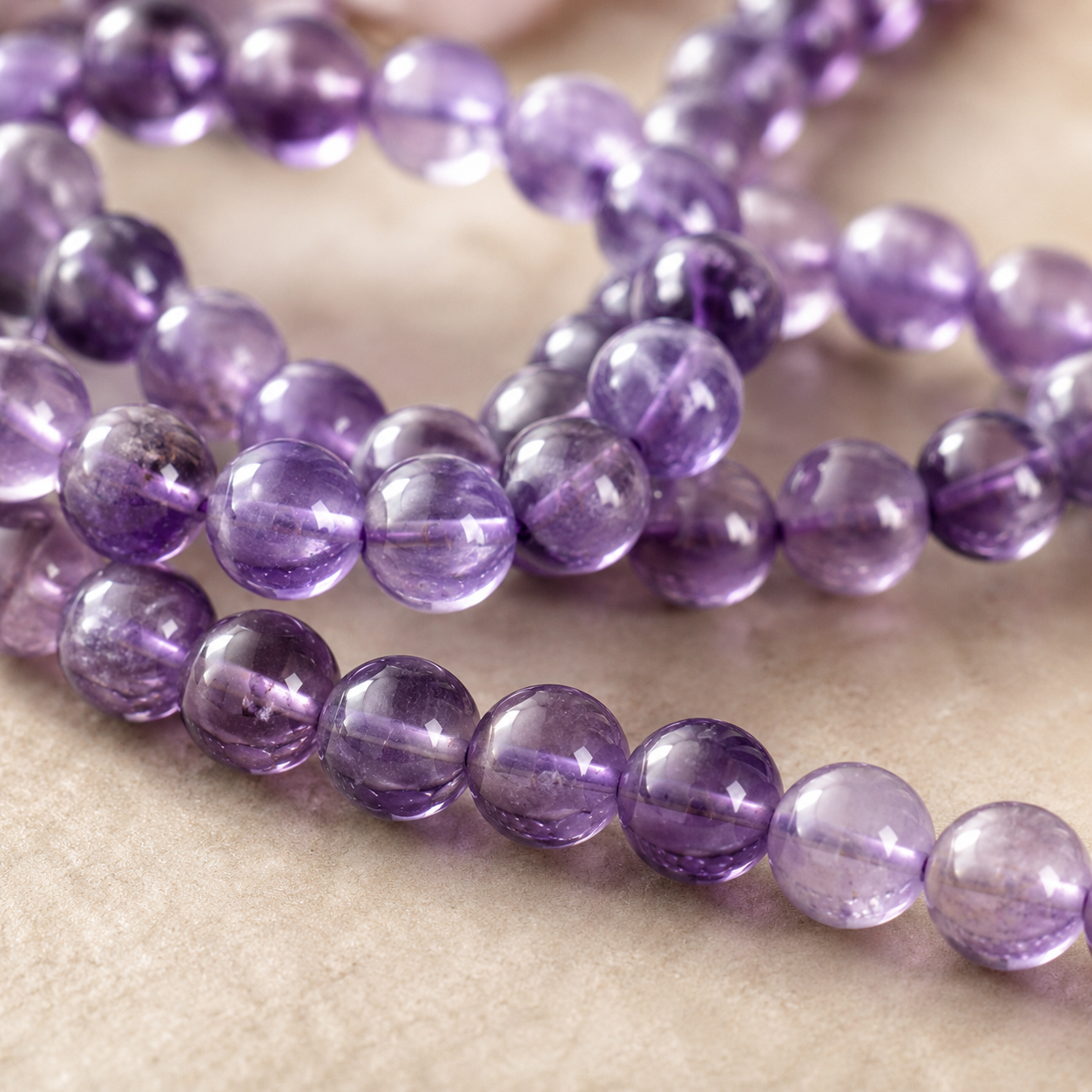 Gros plan sur les reflets violets et la transparence de perles d’améthyste naturelle