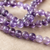 Gros plan sur les reflets violets et la transparence de perles d’améthyste naturelle
