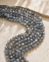 Perles facettées en labradorite sur pierre beige