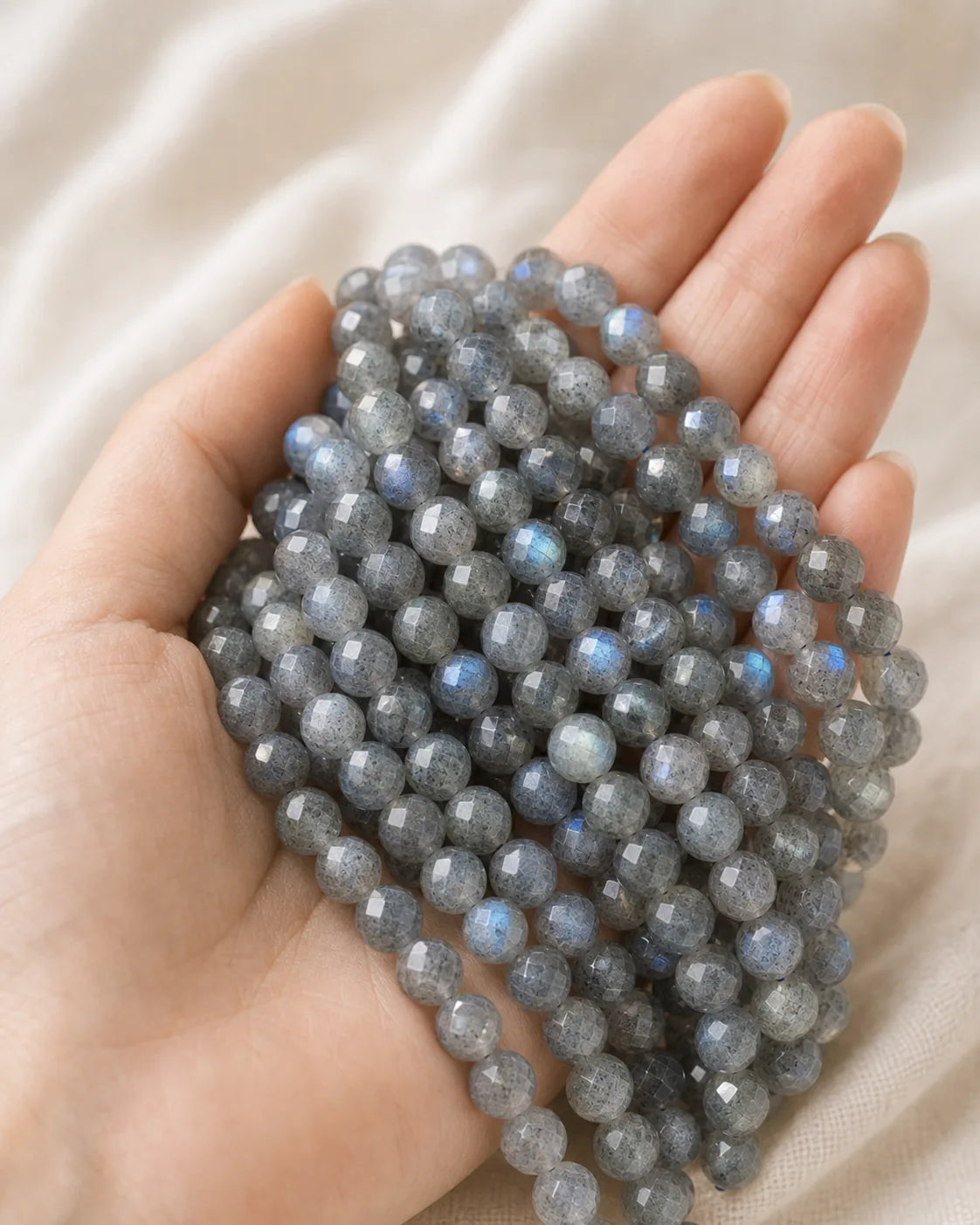Perles facettées en labradorite présentées dans une main