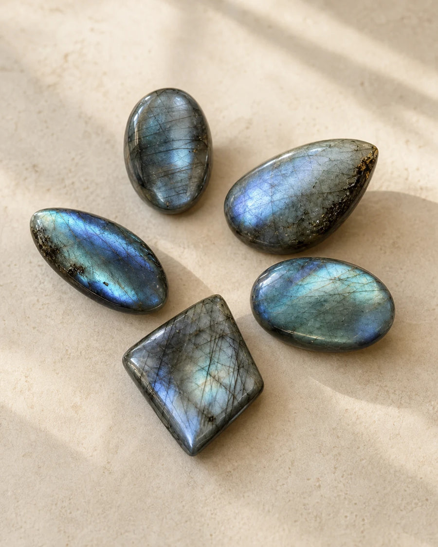 Lot de cinq pierres polies en labradorite sur pierre beige