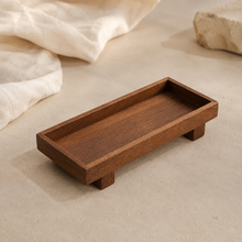 Plateau rituel en bois foncé posé sur une surface beige dans un univers minimaliste Solivaya
